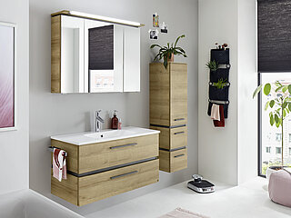 Bad Rimini: VZ-Angebot 1, best. aus: Mineralmarmor-Waschtisch Weiß BME013M10101, Waschtisch-Unterschrank W01013M9904 mit 2 Auszügen inkl. Kosmetik-Einsatz, ca. B 101/99, H 53, T 46 cm, Spiegelschrank SEKE0051004 mit Kranz inkl. LED-Beleuchtung, ca. B 101, H 73, T 17/23 cm, Front und Korpus Riviera Eiche quer Nachbildung, Akzentfarbe Oxid Dunkelgrau quer Nachbildung, Griff Quarzgrau matt: Gegen Aufpreis: Handtuchhalter ZHH4320 zur Korpusmontage, Waschtischarmatur (Achtung: Die fotografierte Armatur wurde nicht aufgenommen. Siehe Preisliste!)