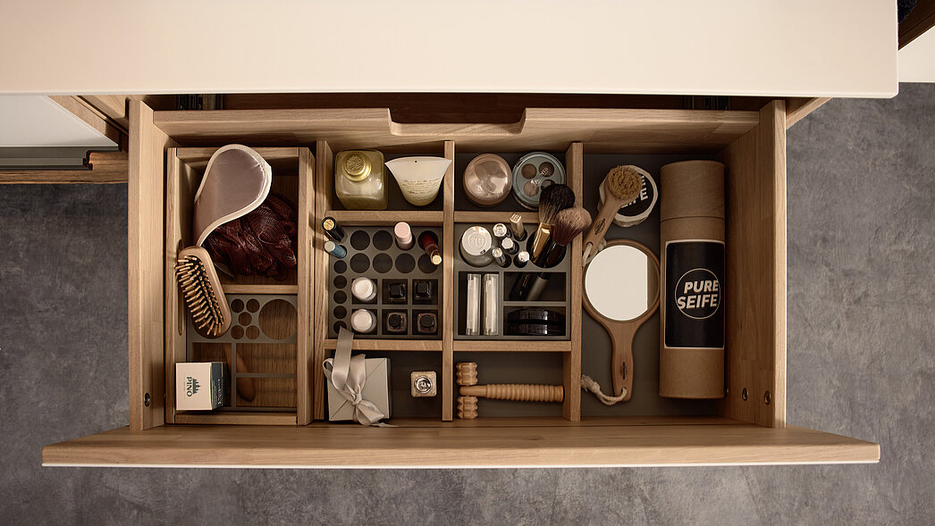 links Utensilienbox groß 810967, Eiche massiv lackiert, ca. B 34, H 11, T 18 cm, mit Kosmetikmetalleinsatz grob 810959 in Lack grau, mittig Schubkasteneinsatz groß 810964, Eiche massiv lackiert, ca. B 51, H 7, T 36 cm, mit Kosmetikmetalleinsätzen grob 810959 und fein 810958 in Lack grau