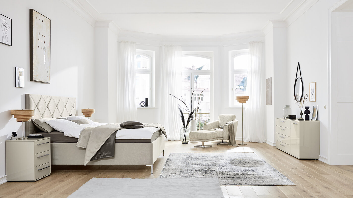 Polsterbett (0153848), Liegefläche ca. 180 x 200 cm, mit integriertem Bettkasten, Kopfteil Epos P8 (03136) mit Rautensteppung, ca. B 196, H 133, T 207 cm, Federholzrahmen Epos Basic Flex, 2x Orthomatic Matratze (03189) First Class TT, H2/H3, Bezug 967, in Stoff (PG 2, z. B. 9875, 97 %
Polyester, 3 % Baumwolle) Zubehör:
1x Wendeplaid für 180er Breite (0050338), Stoff: 9875 (PG 2), Stoff hinten 9874 (PG 2)
Kissen 40 x 80 cm (0198528), 	Stoff 9875, Keder 9874 taupe (PG 2)
Kissen 40 x 40 cm (0198526), 	Stoff: 9874, Keder 9875 (PG 2) 
Kissen 40 x 40 cm (0198526), 	Stoff: 9875, Keder 9874 (PG 2)