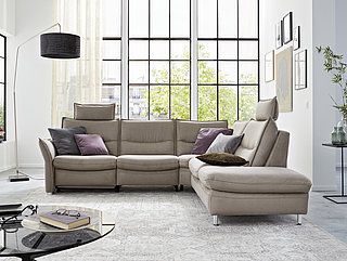 Corner suite, comprising: Modular sofa, 2.5-seater (2.5L) with adjustable armrest on left, optional WallAway function, single-motor (WA1, 2.5 LW), rounded corner piece (right), modular sofa, 2.5-seater, fold-out footstool on right (1.5AhoF R), side length approx. 273 244, H 91, D 92, SH 44, SD 53 cm, 2 headrests, approx. W 64, H 25, D 16 cm (headrests) adjustable in height and angle, Solea stone fabric (VZ PG 20), (NS: 100% polyester, GS: 65% polyurethane, 35% polyester), aluminium metal foot


