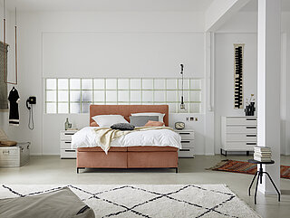 Boxspringbett, bodenfrei, Kopfteil 8 mit Knopfheftung, Stoff JAB 07062, orange (PG JAB 0), Liegequalität Typ 1B2 / 1B3, Untergestell mit Bonellfederkern, Matratzenbezug mit Möbelstoff glatt, geteilt, Links: 7-Zonen-Tonnentaschen-FDK H2, Rechts: 7-Zonen-Tonnentaschen-FDK H3, Fuß: 4 schwarz, Liegehöhe 61 cm (ohne Topper), Liegefläche ca. 180 x 200 cm, ca. B 190 x H 123, T 210 cm. Zubehör:
Matratze H3, 7-Zonen-Mehrschicht-Klimatopper, Kaltschaum, ca. 180 x 200 cm,
Stoff JAB 07062, orange (PG JAB 0):
1 x Plaid, ca. 240 x 70 cm, 1 x 2er-Set Kissen, ca. 40 x 40 cm, 1 x 2er-Set Kissen, ca. 40 x 60 cm