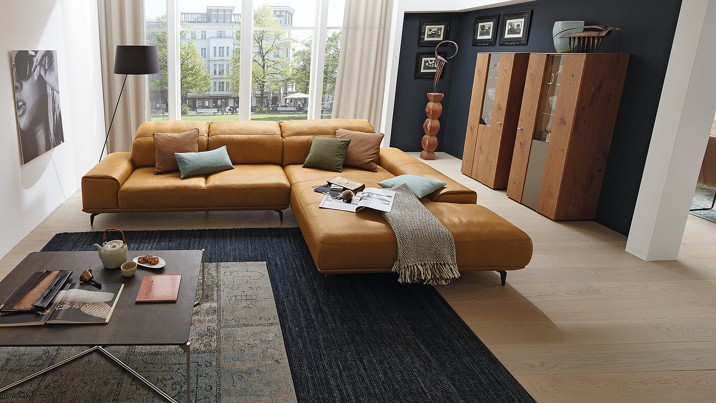 Eckgruppe, bestehend aus Anreihsofa 2-sitzig, Armlehne links (N80L) und Longchair, Armlehne rechts (K105R), Gegen Aufpreis: motorischer Sitzauszug (A02), Kopfteilverstellung (KV2, KV1), Zubehör MR 2999  
ca. 342 x 207, H 87, SH 46 cm
in Echtleder Z 69/52, Fb. Kurkuma (LK 50) mit Kontrastfaden, Metallfuß F C3/Metallfarbe M56 bronze