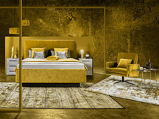 Epos upholstered bed, lying surface approx. 180 x 200 cm, with integrated bed frame and plinth, Epos P6 headboard (03128), straight-lines, approx. W 196, H 133, D 7 cm, 10040 golden yellow fabric (JAB PG 3), 50% cotton, 35% polyacrylic, 10% polyester, 5% other fibres, plinth H 15 cm, slate grey lacquer, Orthomatic matttresses, Epos Trio-Flex, set of 2 LED under-bed lighting; accessories: 1 x reversible throw for 180-cm beds, 130 x 240 cm (0050338), JAB 10040 golden yellow fabric (PG 3), fabric on reverse JAB 10093 (PG 3), 2 pillows 40 x 80 cm (0198525), JAB 10093 grey fabric (PG 3), 2 cushions 60 x 60 cm (0198520), JAB 10040 golden yellow fabric (PG 3), 2 cushions 40 x 40 cm (0198508), JAB 10040 golden yellow fabric (PG 3), 2 cushions 40 x 40 cm (0198508), JAB 10093 grey (PG 3)
