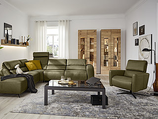 Corner suite incl. fold-up back pad (manual), side length approx. 248 x 281, H 82-107, SH 45, SD 52-59 cm, comprising: modular sofa, 1.5-seater, matching footstool on left (AhoL1,5KV), round-corner piece (REKV), modular sofa, 2.5-seater (2,5RKV), armrest on right, in Vivre moss genuine leather (PG 58), tone-on-tone felled seam, armrest A, metal base in black


