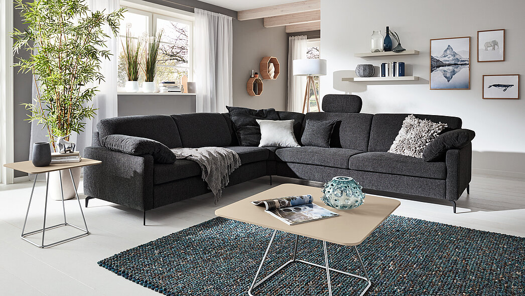 Eckgruppe, best. aus: Anreihsofa 2-sitzig, Armteil links (N80L), Spitzecke (E), ca. 94x94 cm, Anreihsofa 2-sitzig, AT rechts (N90R), Kopfstütze U92, ca. B 51, H 24, T 12 cm, 2 Seitenteilkissen U, 50x45 cm, diverse Kissen
ca. B 266 x 286, H 82, SH 44, T 91 cm, Stoff R66/28 marine (SK 10) (Nutzschicht: 85 % Polyester + 15 % Nylon Grundschicht 100 % Polyester)
 Fuß FC3 M99 schwarz, Seitenteil SI, Breite 12 cm