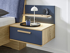 Malin: Hängekonsole in Balkeneiche furniert, Absetzung Lack Lagune Blau, ca. B 60, H 23, T 46 cm. Zubehör: Paneelaufsatz rechts mit Holzboden (20226), indirekte LED-Holzbodenbeleuchtung (80027).