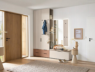 Garderobe des Modells Ovida der Marke Musterring
Vozugskombination AVZ05, inkl. LED-Beleuchtung im Hängespiegel und Schubkasten in Glas, Dekor Cotton, Glas satiniert Lack Zirkon, Griffe und Haken in Schwarz, Sitzpolster in Creme, ca. B 220, H 262, T 40 cm. Zubehör: 1 x indirekte LED-Beleuchtung für Garderobenaufsatz, 1 x indirekte LED-Beleuchtung für Garderoben-Hängepaneel.