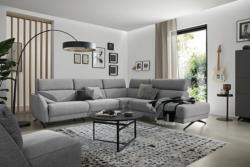 MR – MR 9440 | 6956021 | 260401 
MR 9445 | 6956022 | 260401 
Deluxe Collection | 9509600 | 260401 
Musterring Leuchten | 9669602 | 250401 
Maestra | 3651080 | 260101 
JustB! CT100 | 7807080 | 260401 
JustB! KM100 | 7417000 | 250401 
Musterring Heimtextilien | 7579600 | 260401 – Grau – Wohnmöbel,Polstermöbel,Dielen, Couchtische, Einzelteile,Ambiente, Teppiche, Leuchten – Eckgruppe (Vorschlag 1, M300BT270) bestehend aus Anreihsofa, Armlehne links, Anreihelement ohne Armlehnen, Eckelement, Anreihelement mit offenem Abschluss rechts inkl. 5 x feste Kopfstützen, Stoff (PG 3, z.B. Escana stone, 91 % Polyester, 9 % Viskose), Sitzkomfort Standard HR 40, ca. 300 x 270, H 99, SH 47, T 100, ST 60 cm. Zubehör: 2 x Kufe 03BL Black, Rc = Relaxfunktion mit Herz-Waage-Funktion, 5 x E = ELEGANT, manuelle Verstellung der Kopfstütze, Z=ZEN, motorische Kopfteilverstellung